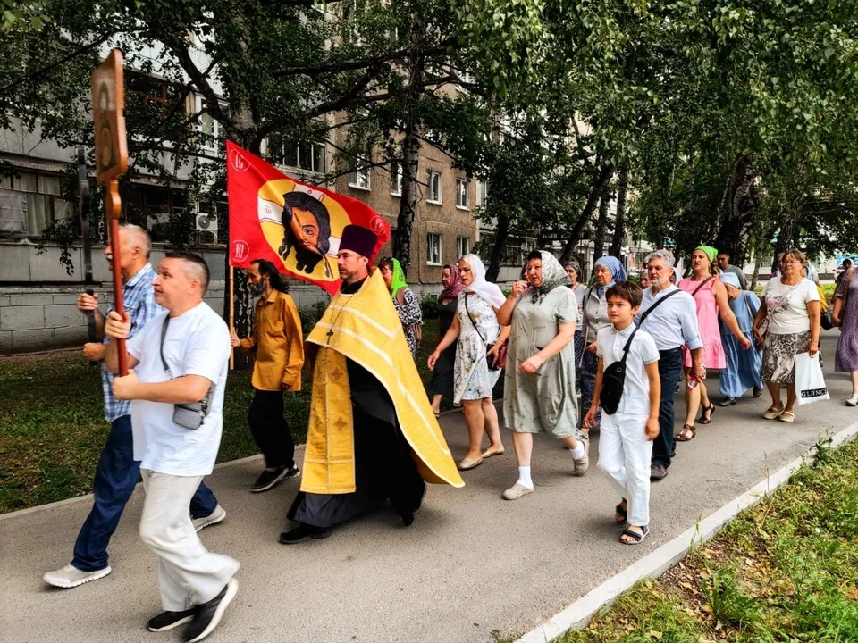 Крестный ход священника и прихожан по улице жилого микрорайона в Уфе